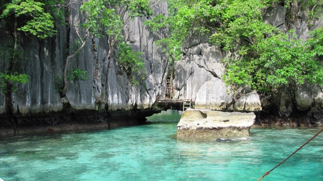 An about 2 meter-wide hole connects the two lagoons.  During low-tide as can be seen in this photo, you can see the hole and can easily swim from one lagoon to the other.  During high tide, it is an exciting adventure to swim through the hole to get to the other lagoon.  Another way to go from one lagoon to the other during high tide is to climb the ladder as shown in the photo.